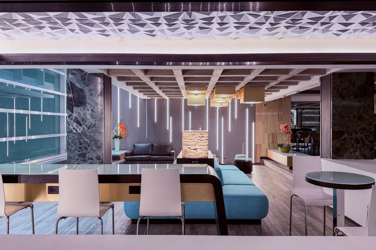 A modern interior with a sofa, chairs, a table, and a decorative wall.