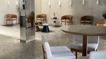 A modern conference room with a round table, six chairs, and a glass partition.