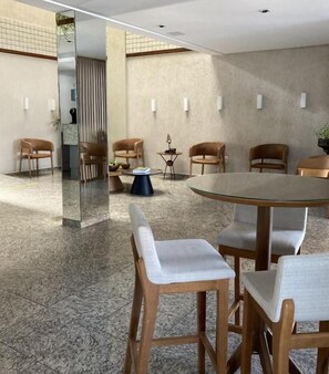 Une salle de conférence moderne, dotée d’une table ronde, de six chaises et d’une cloison en verre.