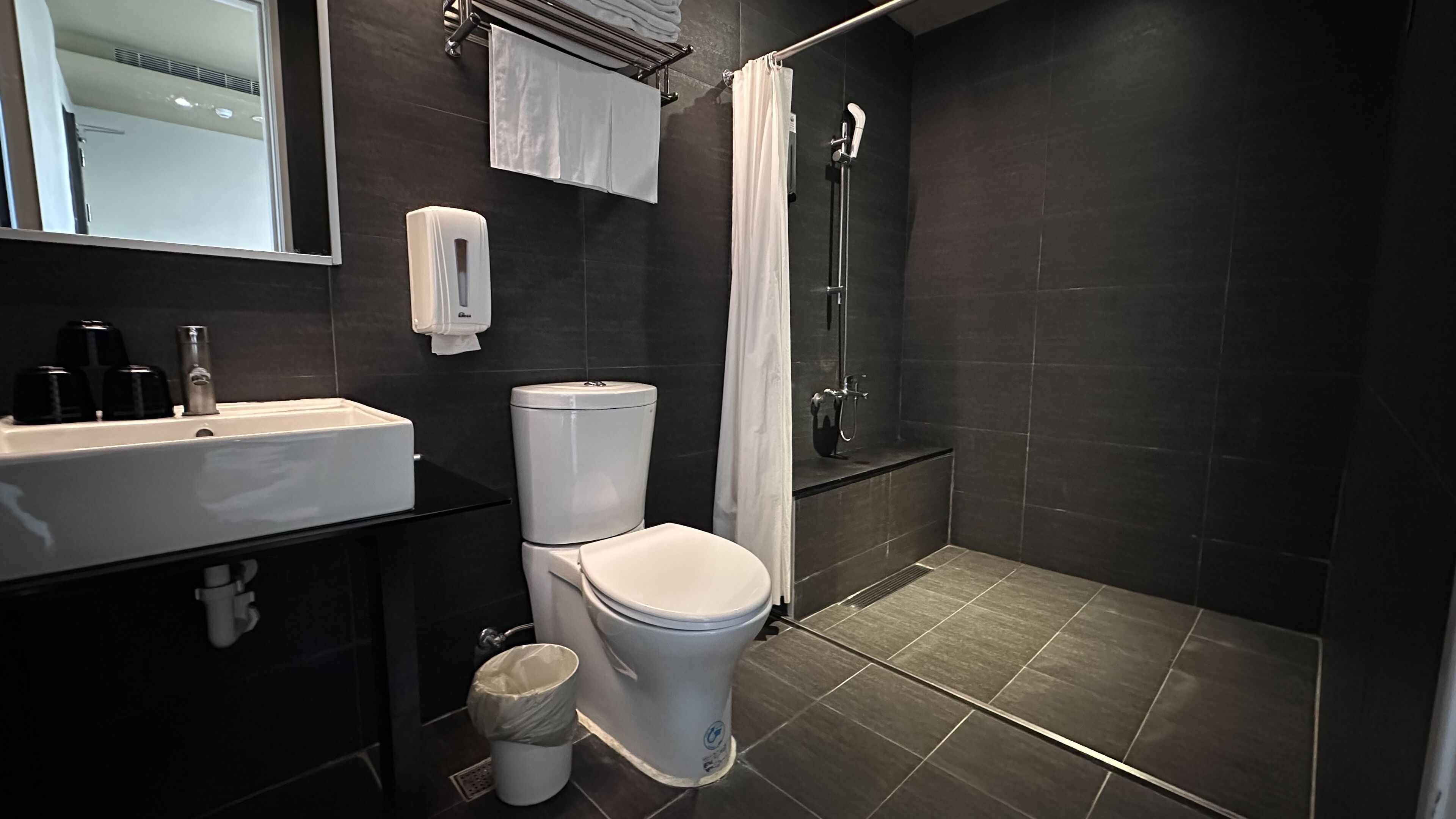 rainfall showerhead, hair dryer, slippers, towels