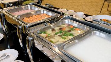 Buffet amb diverses opcions gastronòmiques, com ara hot dogs, verdures i arròs.