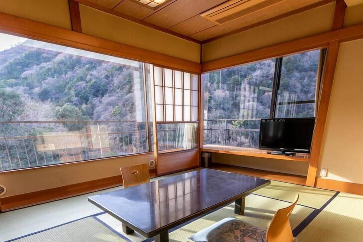 A tatami mat room with a low table and a television on a stand.