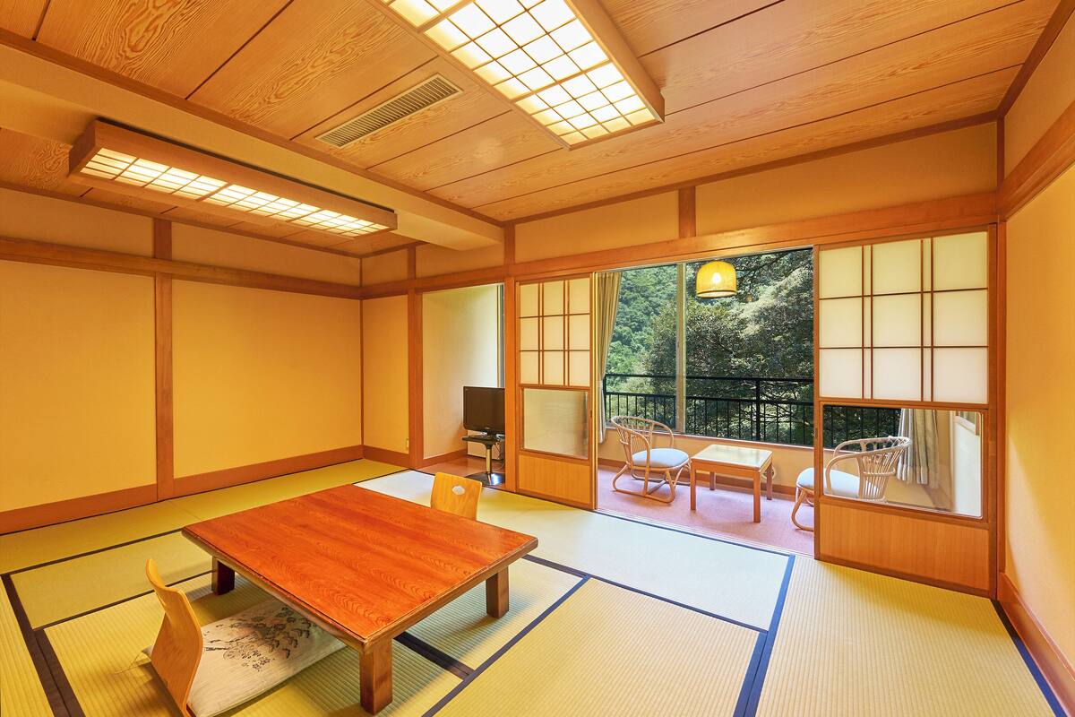 A traditional Japanese room with tatami flooring, a wooden table, and sliding doors.
