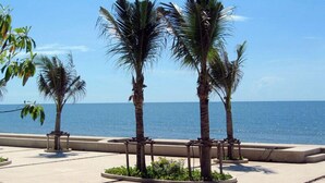 A paved walkway with palm trees and a view of the ocean. - Talay Samran by Lease Back Thailand (Cha-am)