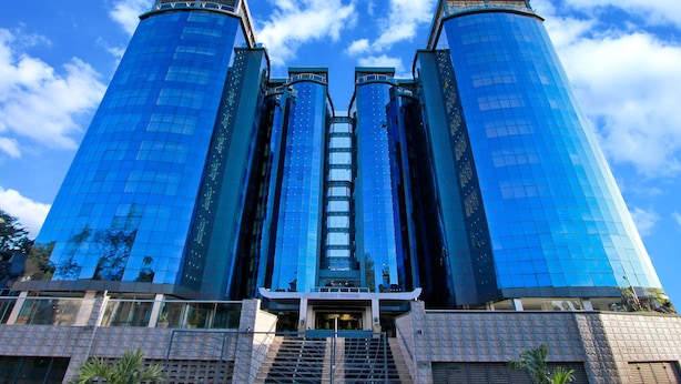 A modern building with three tall towers and a central entrance.