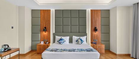 A modern hotel room with a large bed, wooden headboard, and bedside tables with lamps.