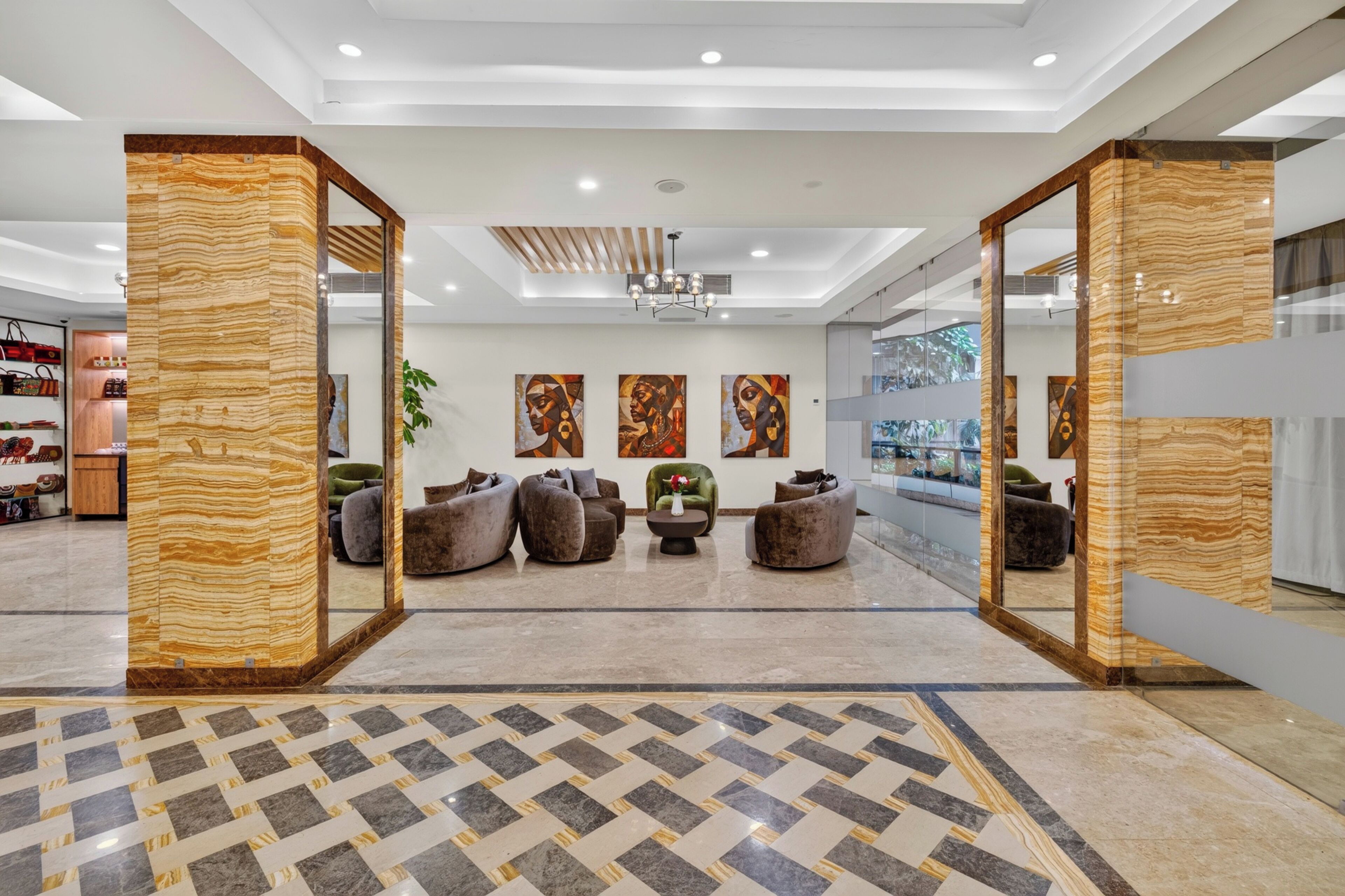 A modern lobby with a geometric patterned floor, contemporary seating, and abstract wall art.