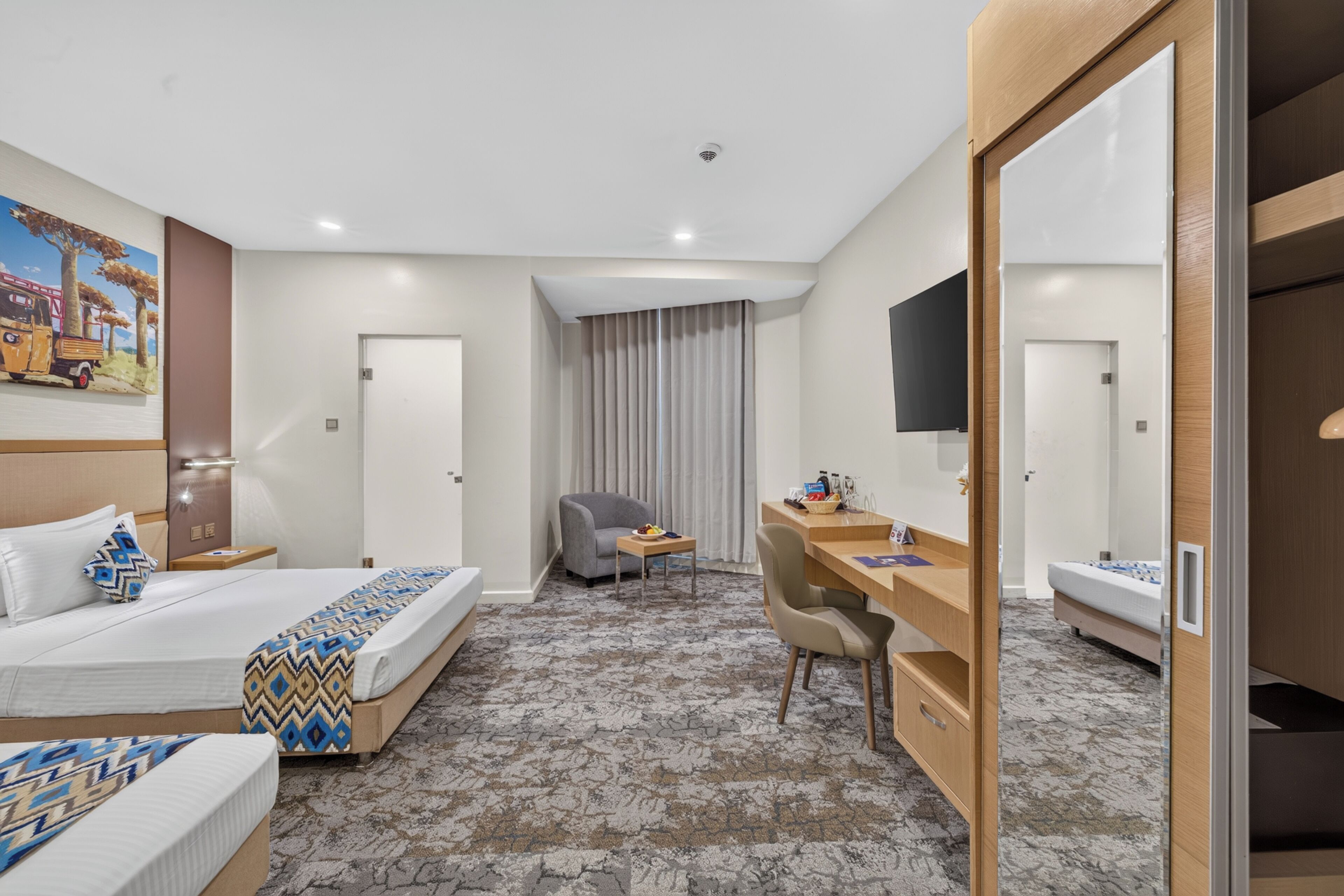 Een hotelkamer met een bed, bureau, stoel en televisie.