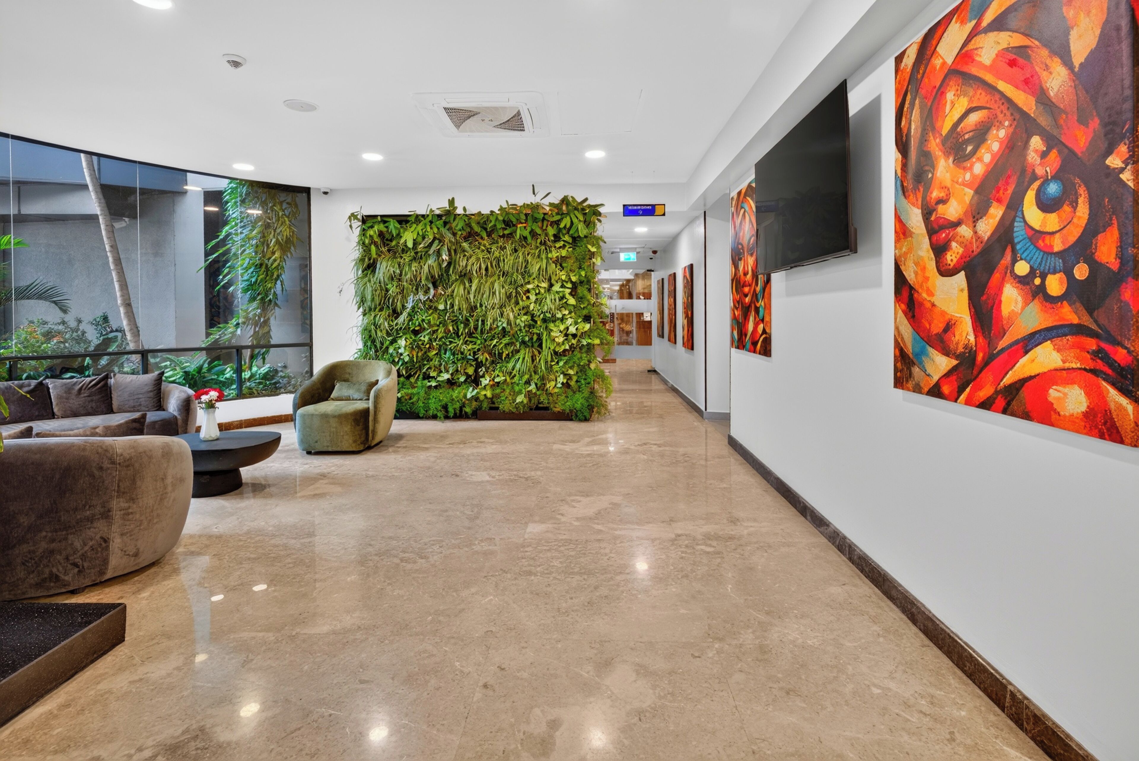 A modern lobby with a green living wall, comfortable seating, and artwork on the walls.