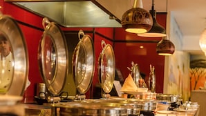 A buffet setup with various food containers and utensils.