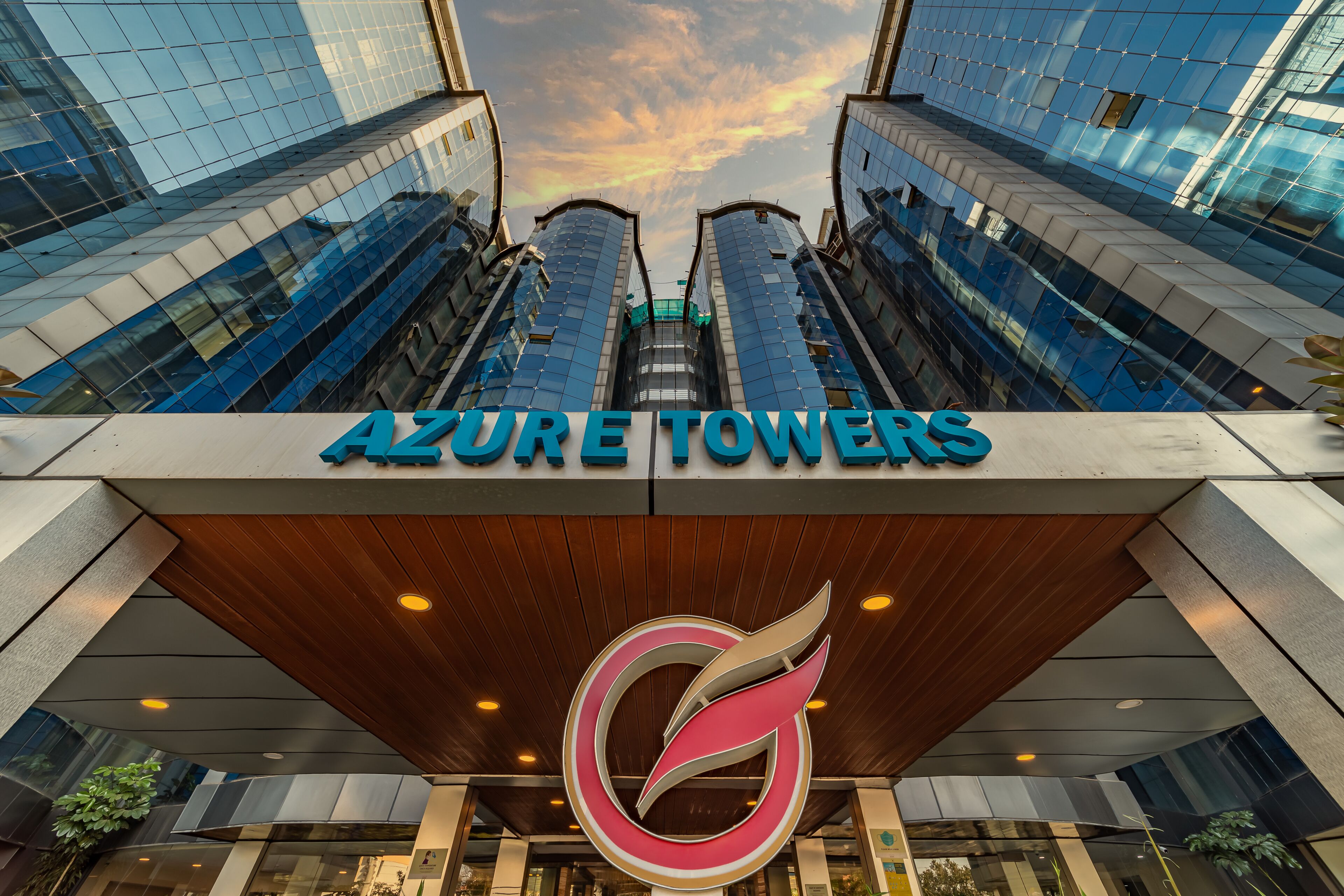 The Azure Towers building with a modern architectural design, featuring a prominent logo and a clear view of the surrounding high-rise buildings.
