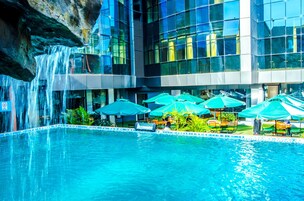 Una piscina al aire libre, sillones reclinables de piscina