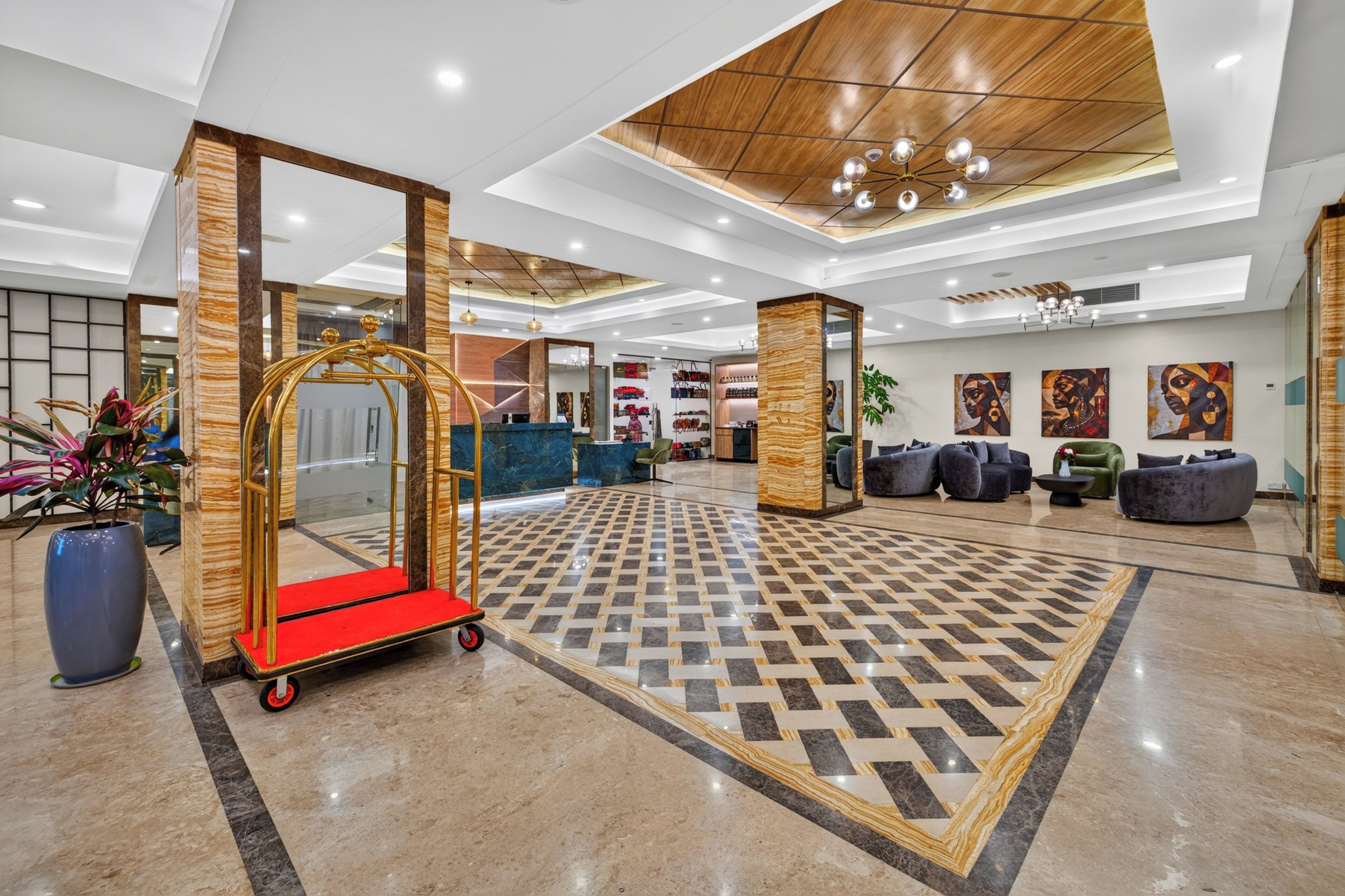 A lobby with a check-in desk, seating area, and artwork on the walls.