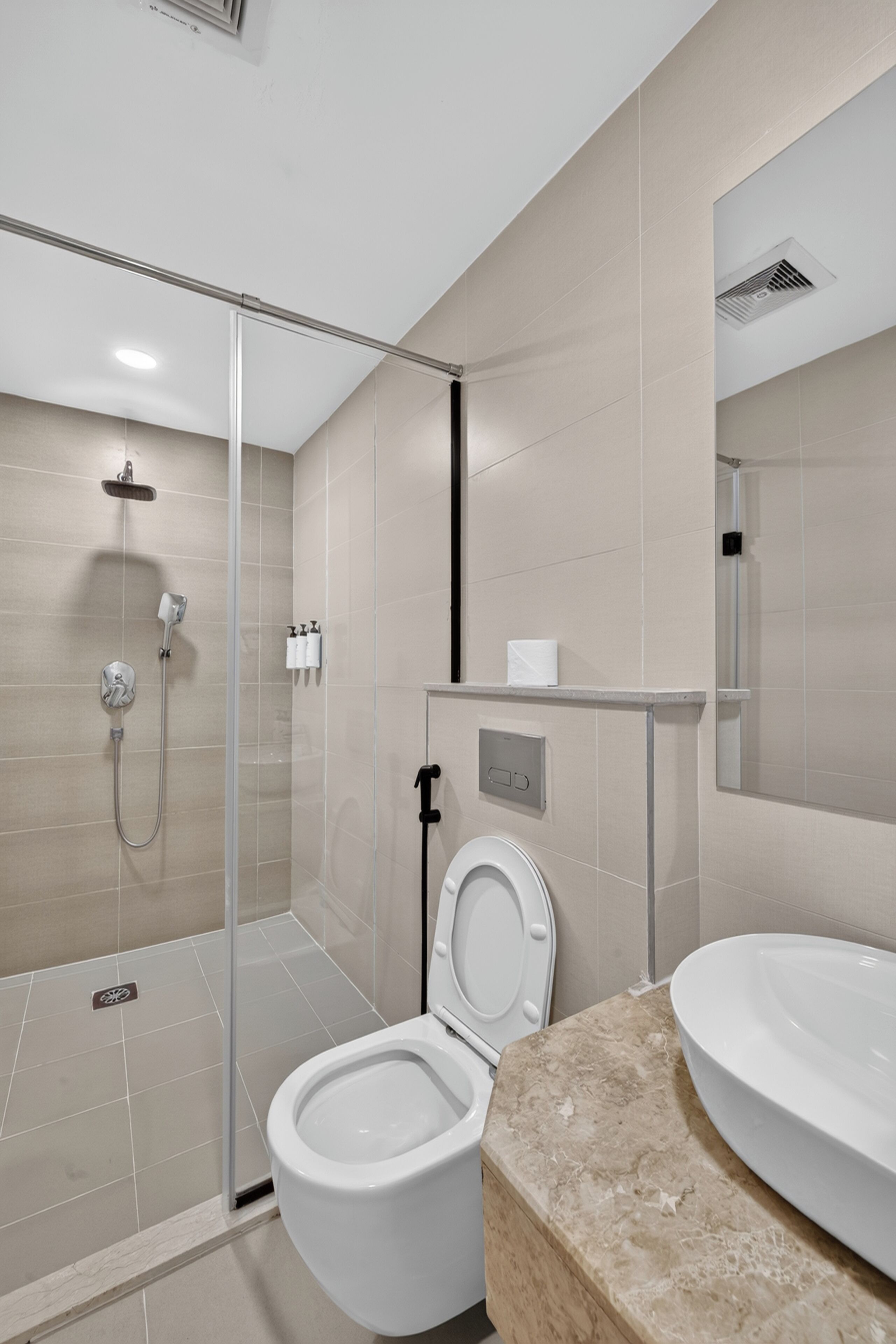 Un baño moderno con ducha acristalada, inodoro y lavabo.