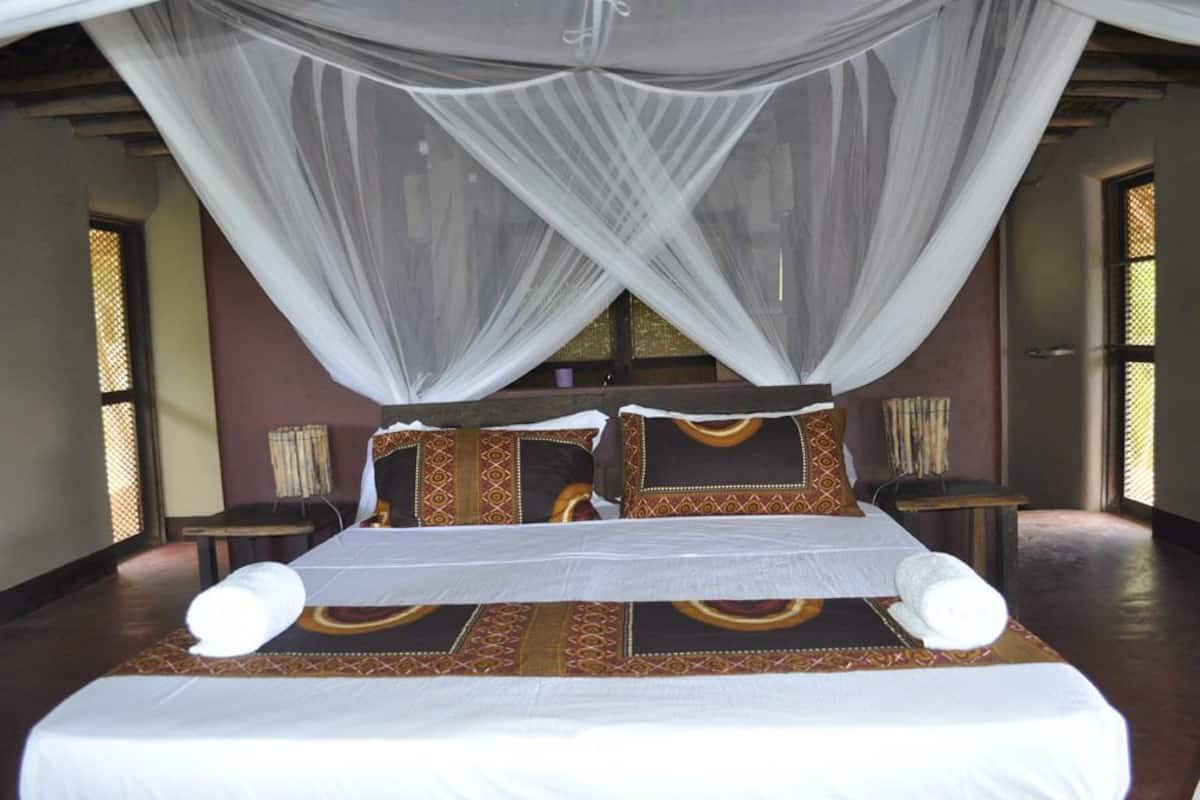 A bed with a canopy, pillows, and a headboard.