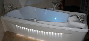 A white freestanding bathtub with a single faucet and a light fixture above it. - Heidehotel Lubast (Kemberg)