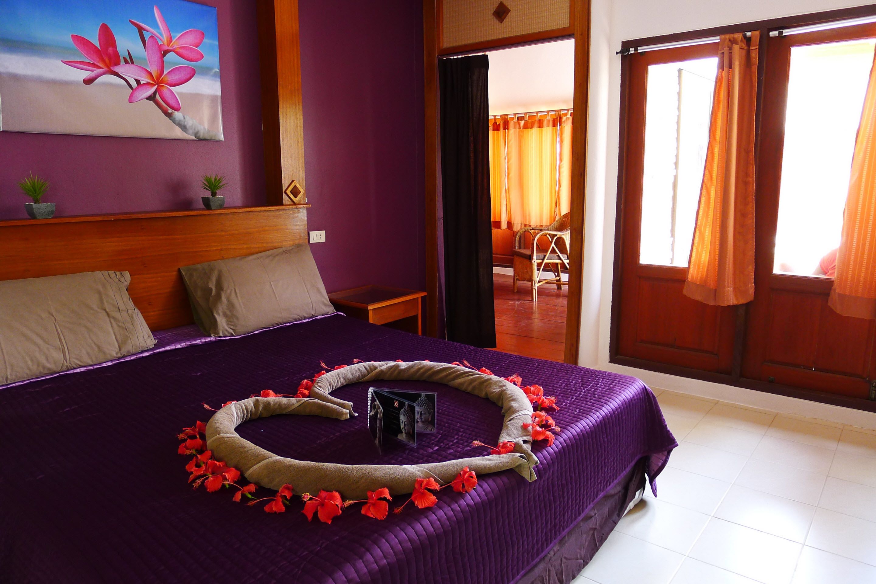 Una habitación con cama, un cuadro y vistas por una puerta.