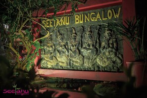 A sign for Seetanubungalow with a relief sculpture of figures. - Seetanu Bungalows (Ko Pha-ngan)