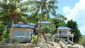 Um imóvel à beira-mar com várias casas, cada uma com varanda e um muro de pedra.