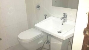 A small bathroom with a toilet and a sink. - Westend Holiday Home (New Delhi)