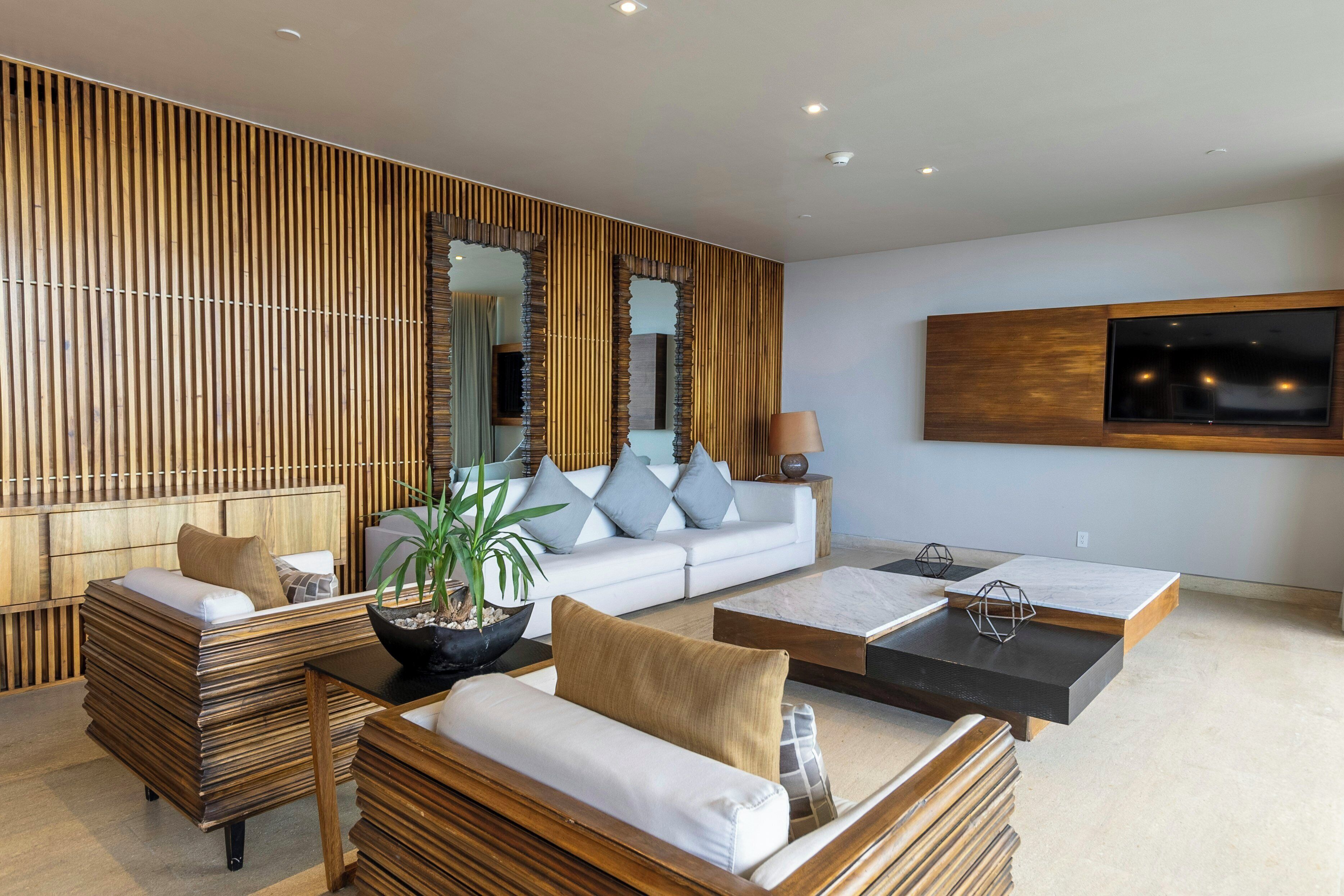 Un salon moderne avec un canapé, une table basse et un grand miroir.