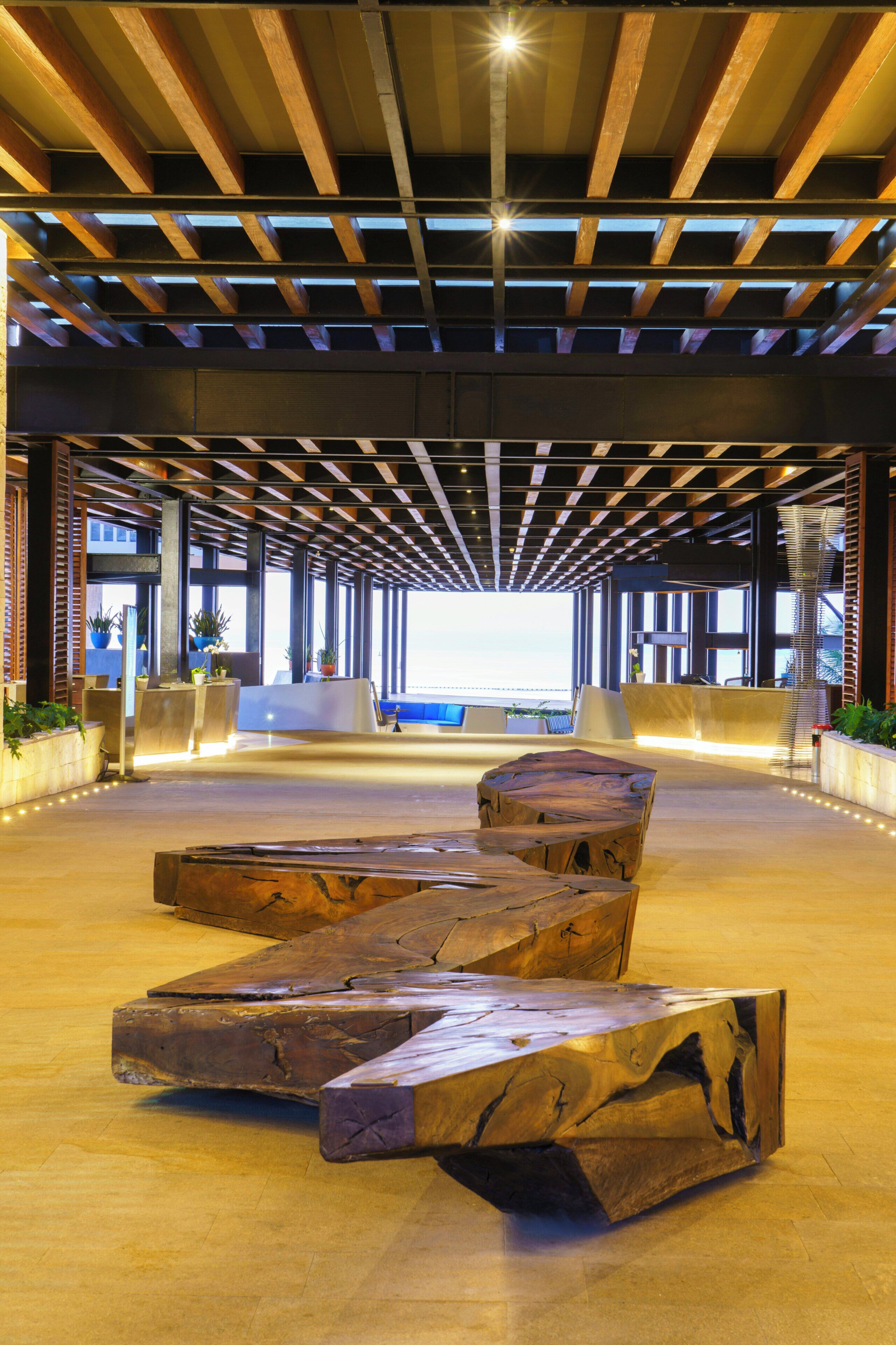 Un hall d’entrée spacieux avec un plafond en bois, un comptoir d’accueil et une grande fenêtre.