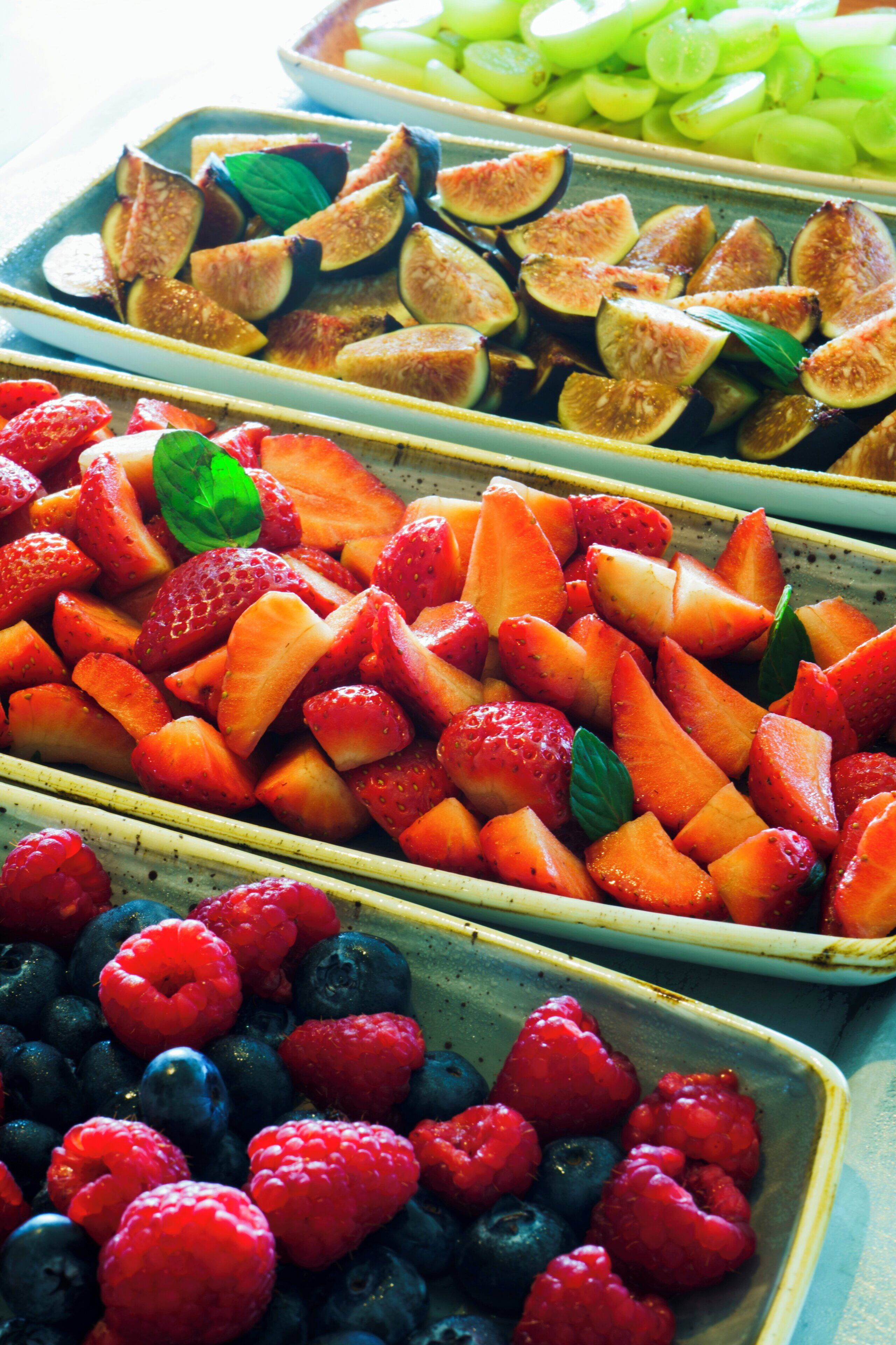 Variedad de frutas frescas dispuestas en bandejas.
