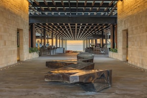Un espace intérieur avec vue sur la mer, comprenant un banc en bois, un coin salon et un bar.