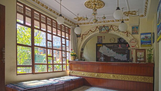 A room with a large window, wooden bench, and a decorative ceiling. - Hotel Discovery Inn (Kathmandu)