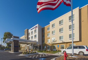 Un hotel Fairfield Inn & Suites con estacionamiento, espacios de estacionamiento accesibles para discapacitados y un hidrante rojo.