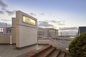 A building with a sign reading "Capo Gordonia" and a staircase leading to a lower level. - First Group Cape Gordonia (Cape Town)
