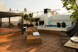 A rooftop terrace with a pool, lounge chairs, and potted plants. - Aguilas5 SevillaSuites (Seville)