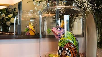 Un terrario de vidrio con una figurita de un colorido sapo.