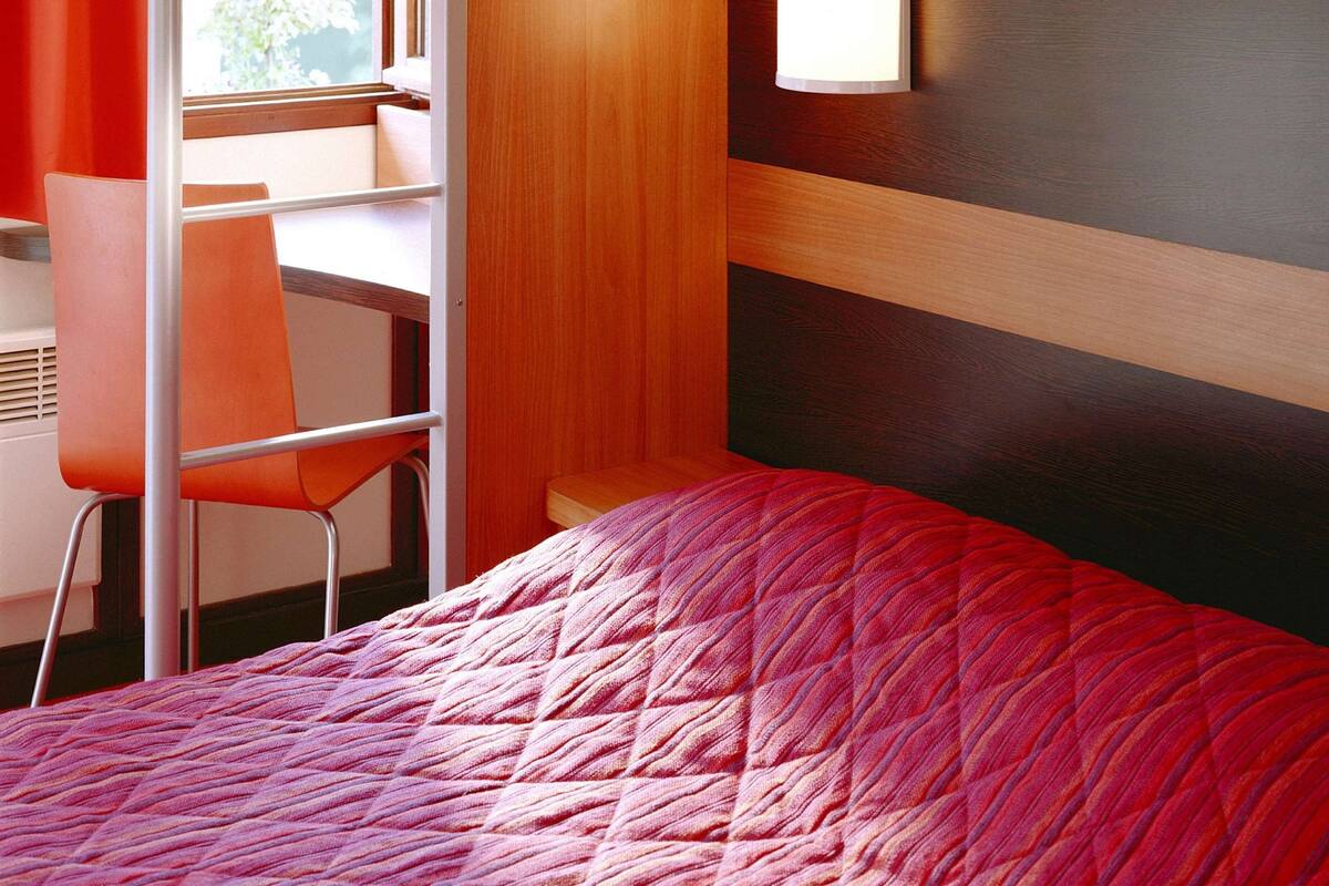 Ein Hotelzimmer mit einem Bett, einem Schreibtisch und einem Sessel.