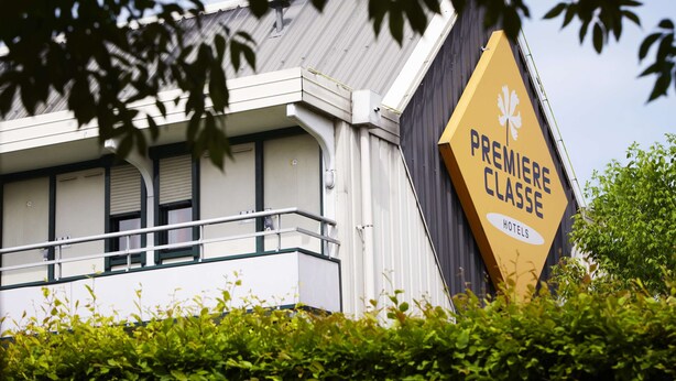 A building with a prominent yellow sign reading "PREMIERE CLASSE HOTELS". - Premiere Classe Saint Ouen L'Aumone (Saint-Ouen-l'Aumone)
