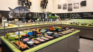 Zona de bufé con diversas opciones de comida y una escultura decorativa de ballena.