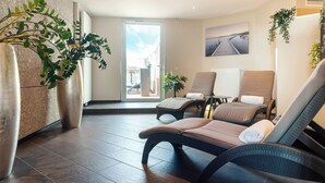Un moderno spa con dos sillones reclinables, una planta grande en maceta y vistas al exterior.