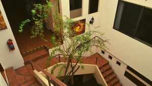 A multi-level interior with a staircase, a fire extinguisher, and a wall-mounted light fixture. - Hotel Don Nino (Oaxaca)