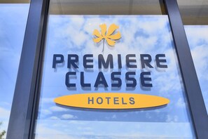 A hotel sign with the name "PREMIERE CLASSE HOTELS" and a maple leaf logo.