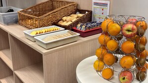 A breakfast buffet with bread, pastries, and fruits. - Premiere Classe Bordeaux Ouest - Mérignac Aéroport (Merignac)