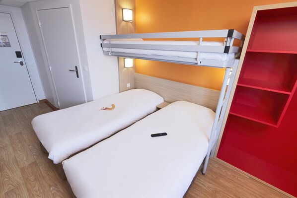 A bunk bed with a red storage unit beside it.