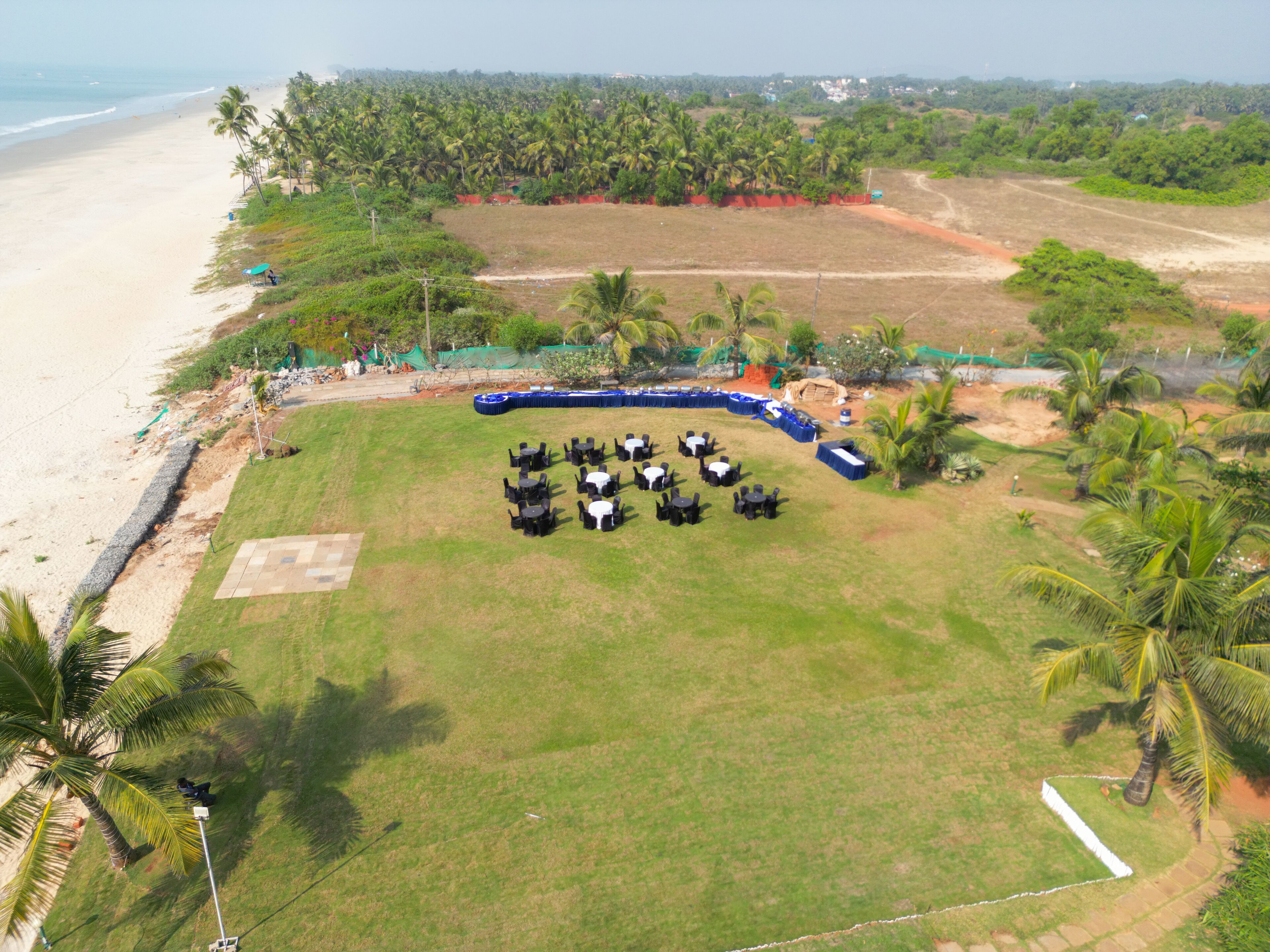 An outdoor event space with a stage, seating, and a beach view.