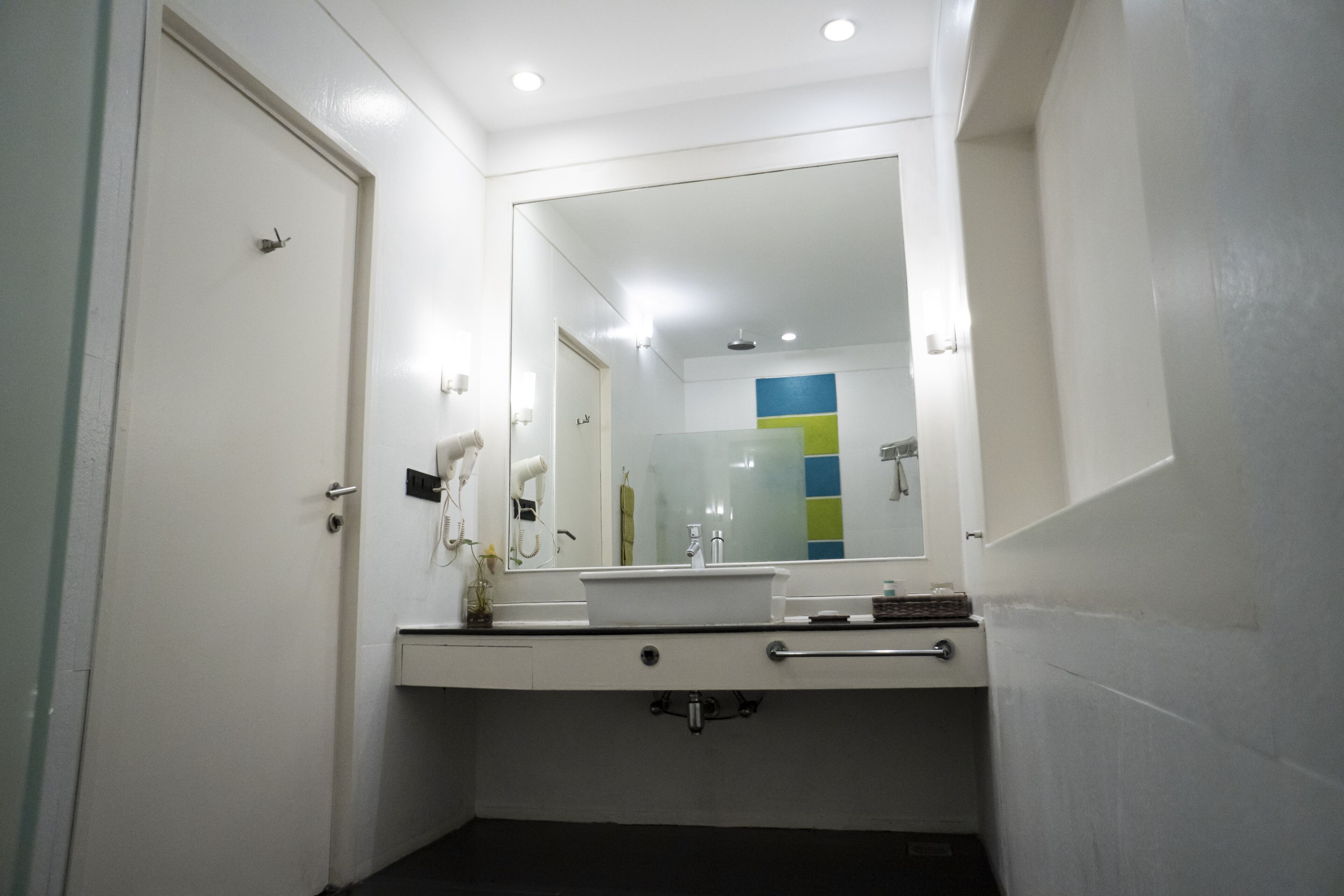 A bathroom with a white sink, a mirror, and a towel rack.