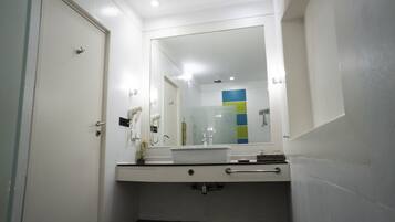A bathroom with a white sink, a mirror, and a towel rack.