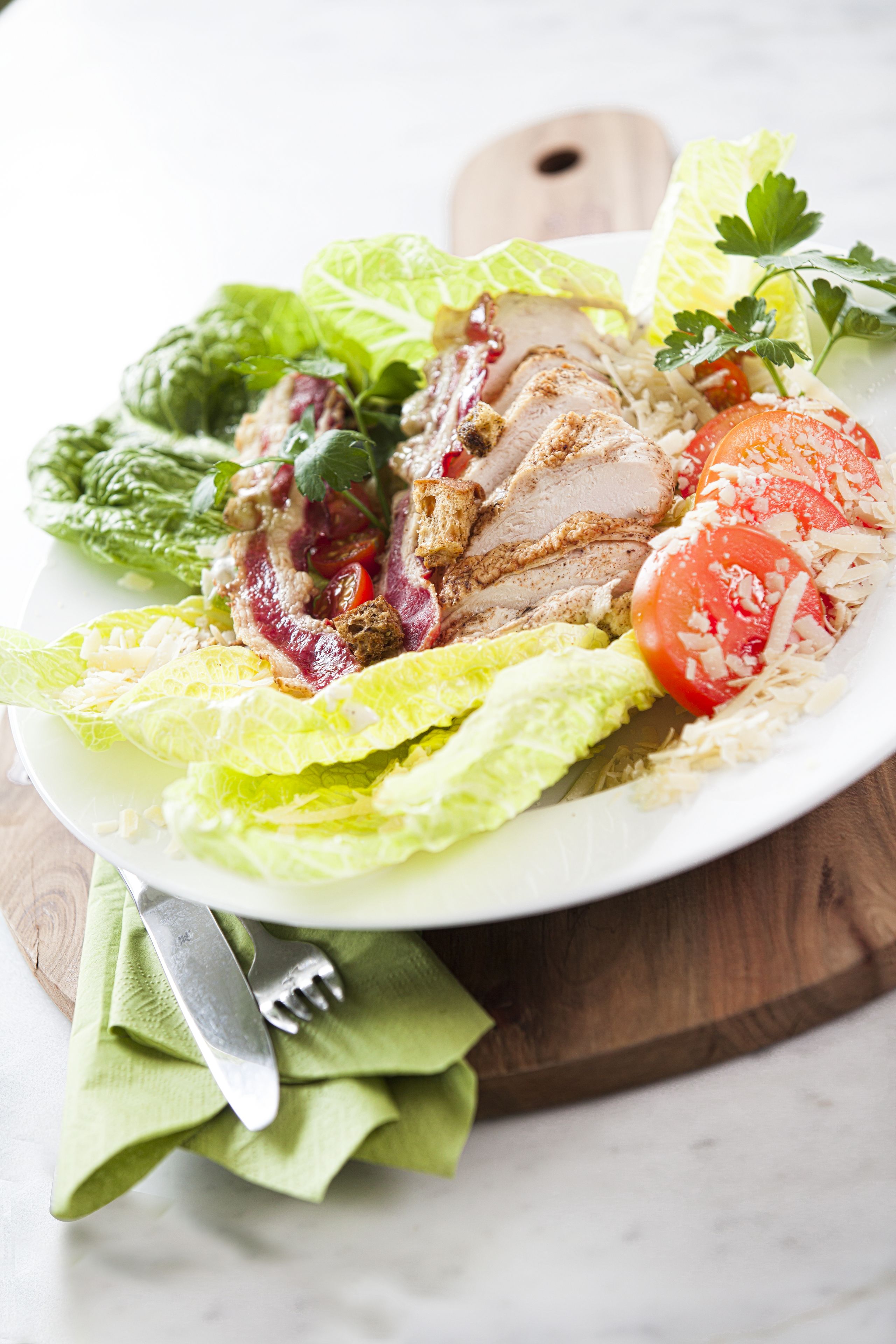 A plate of food with lettuce, tomatoes, and meat.