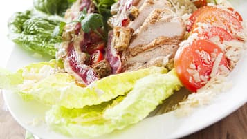 Un plato de comida con lechuga, tomates y carne.