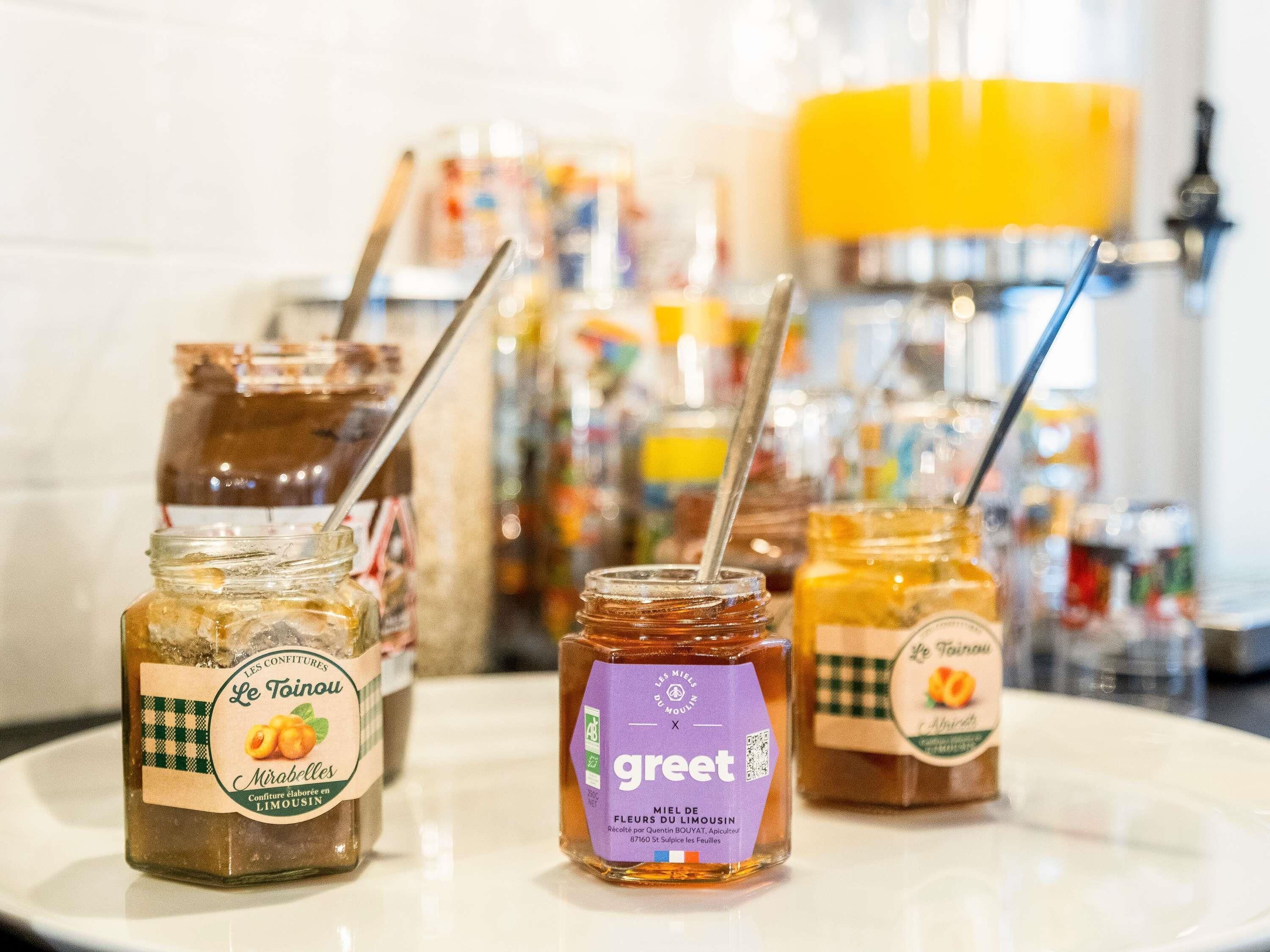 Three jars of honey with labels on a white plate.