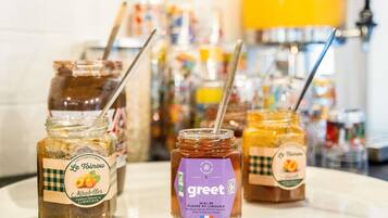 Three jars of honey with labels on a white plate.