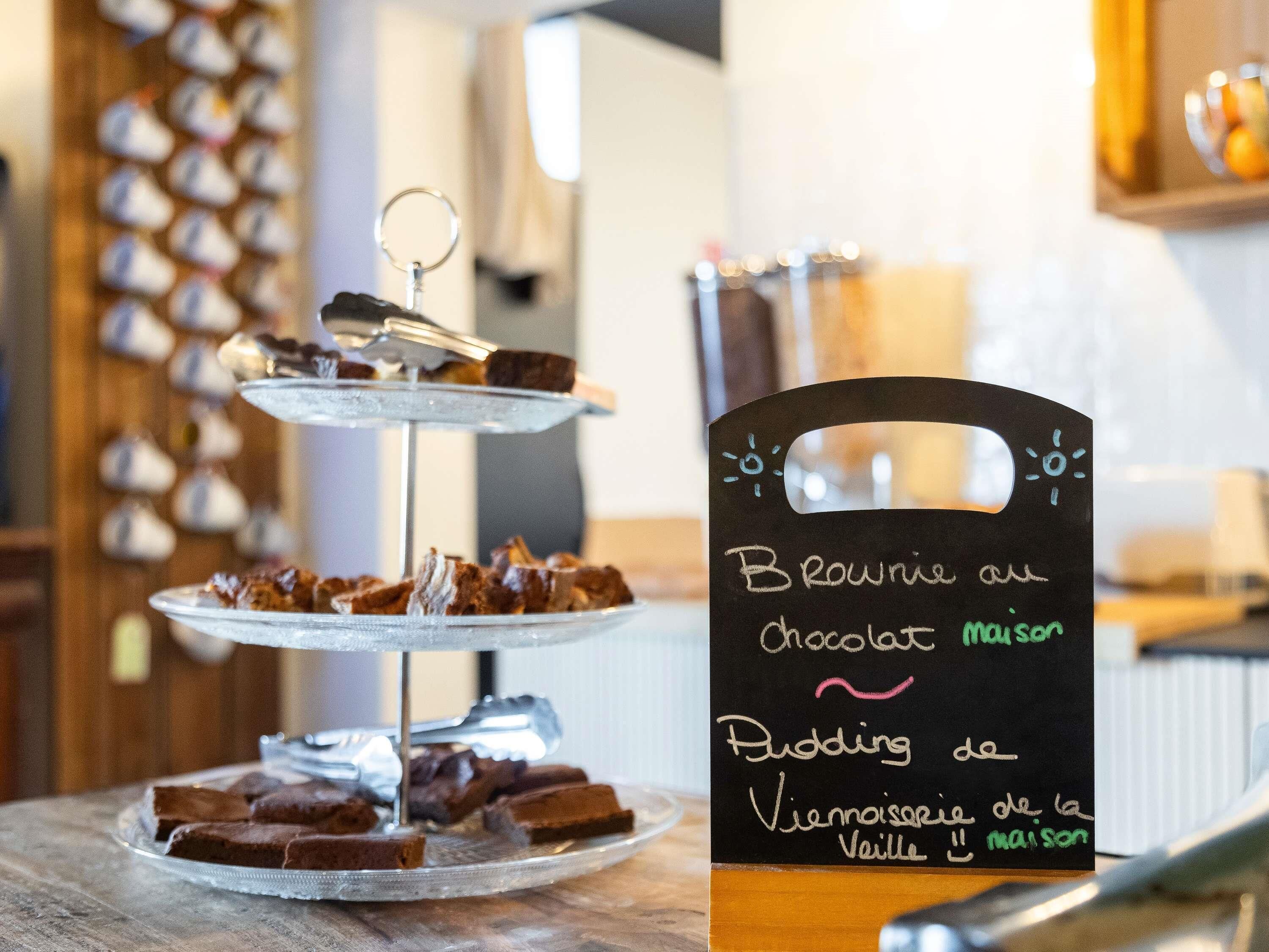 A dessert display with brownies and a sign indicating chocolate mousse and vanilla pudding.