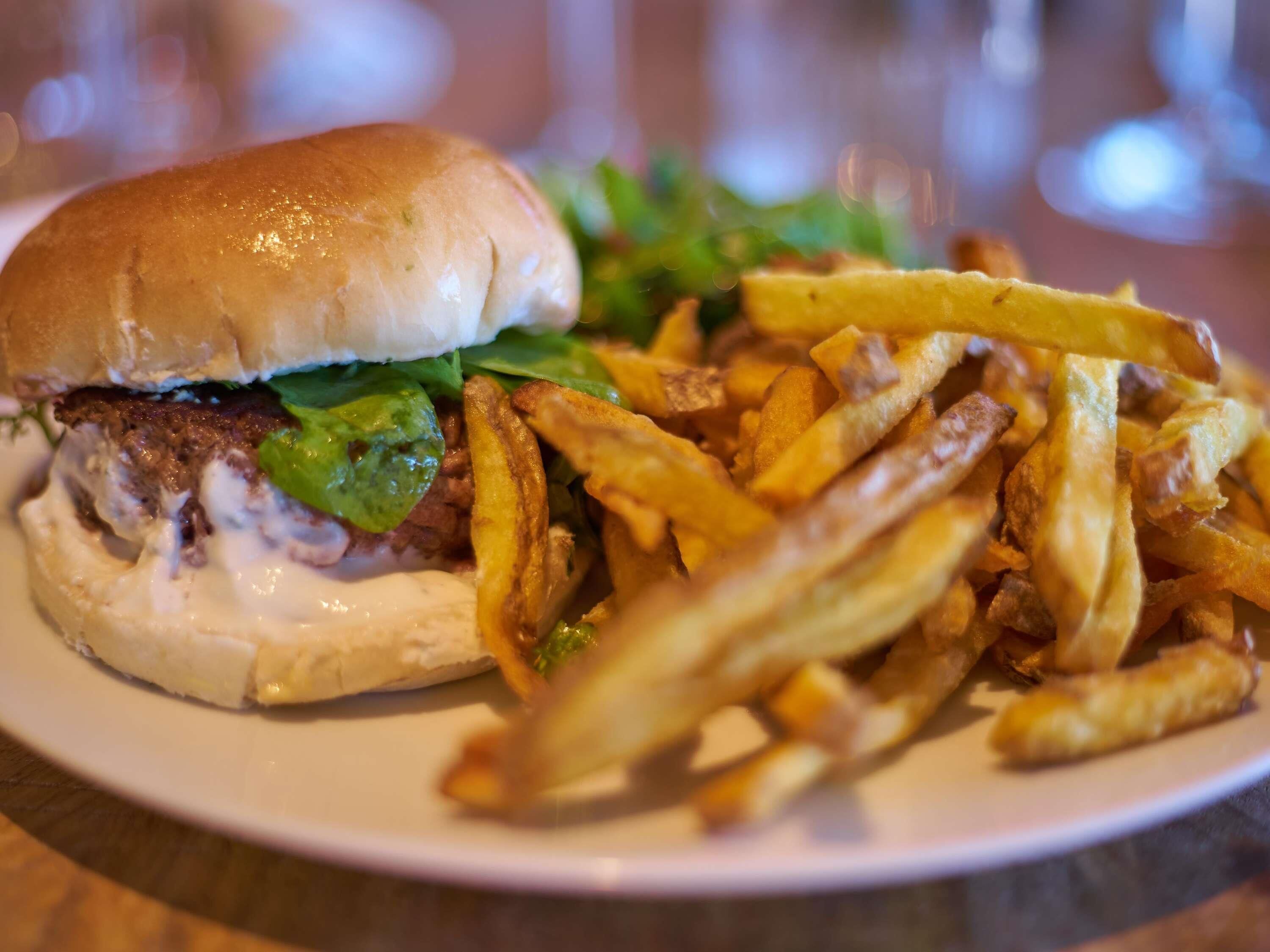 En tallrik med en hamburgare och pommes frites.